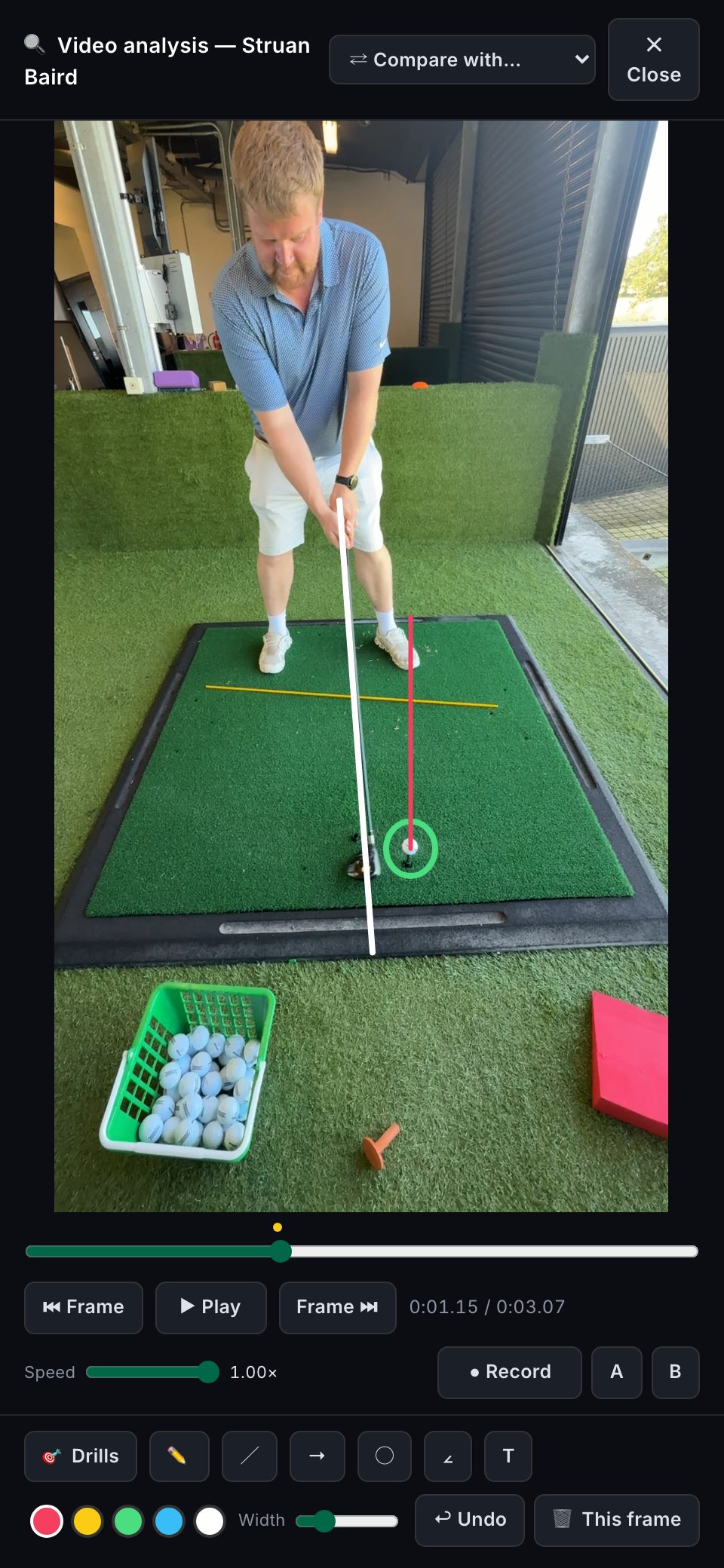 The CoachOS analyzer on a phone: a real swing with the coach's shaft line, ball circle and ball-position line drawn on it.